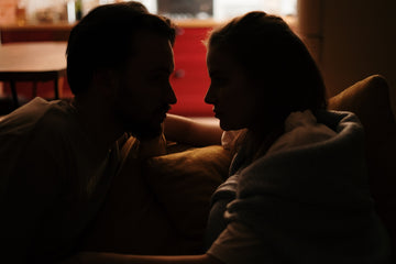 Man and woman staring at each other in a dark room