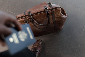 Man standing with a bag and passport