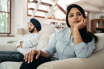 Sad Indian couple sitting on a sofa