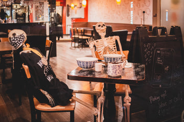 Skeletons placed at a table with dishware