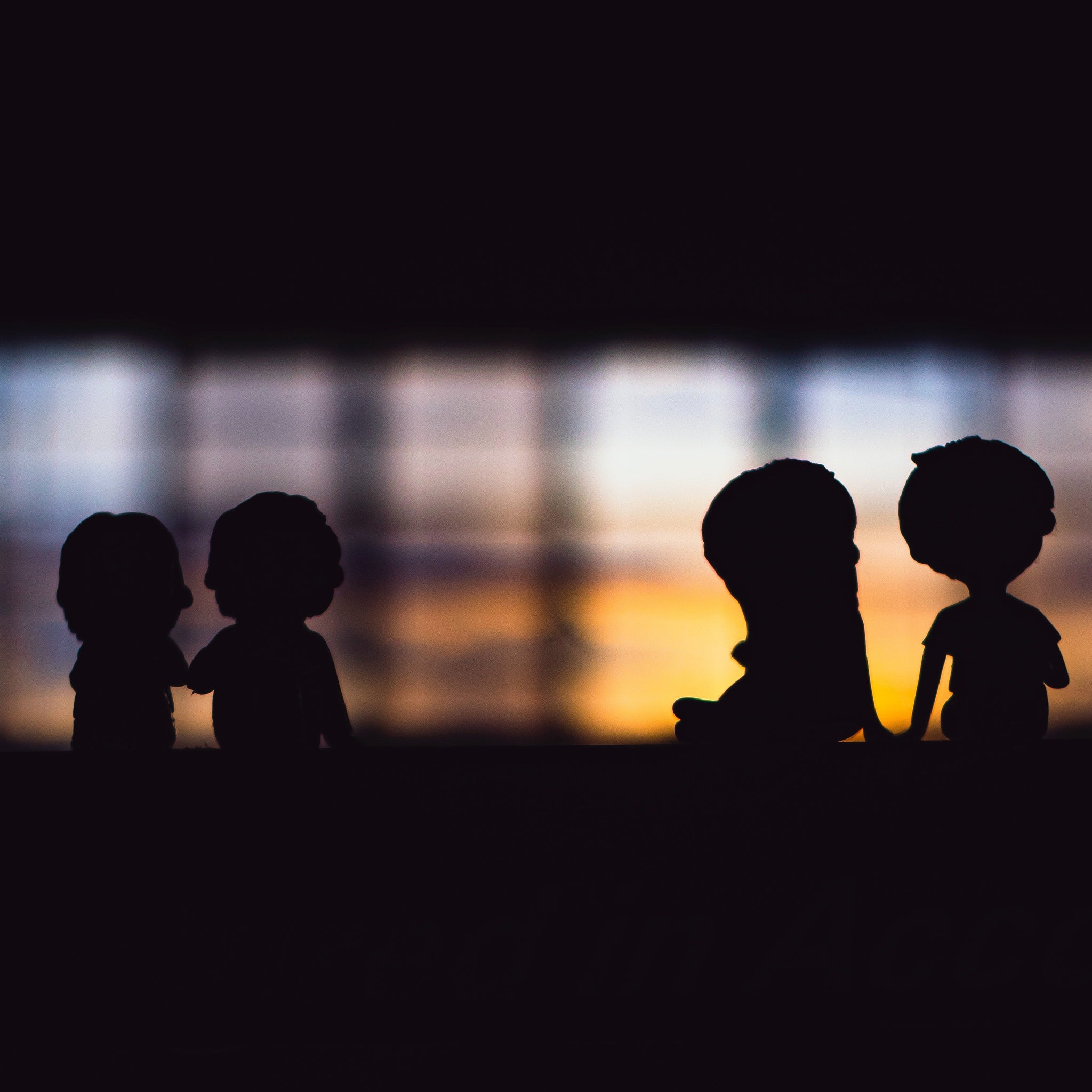 Figurine couples in darkness near window