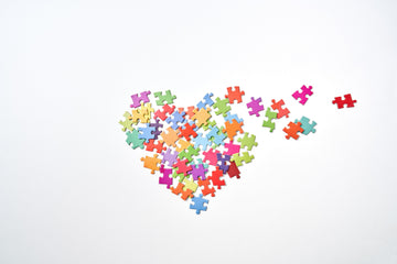 Broken heart-shaped puzzle pieces in a white background