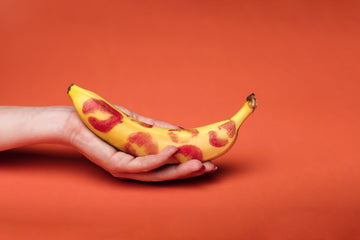 A person holding a yellow banana fruit