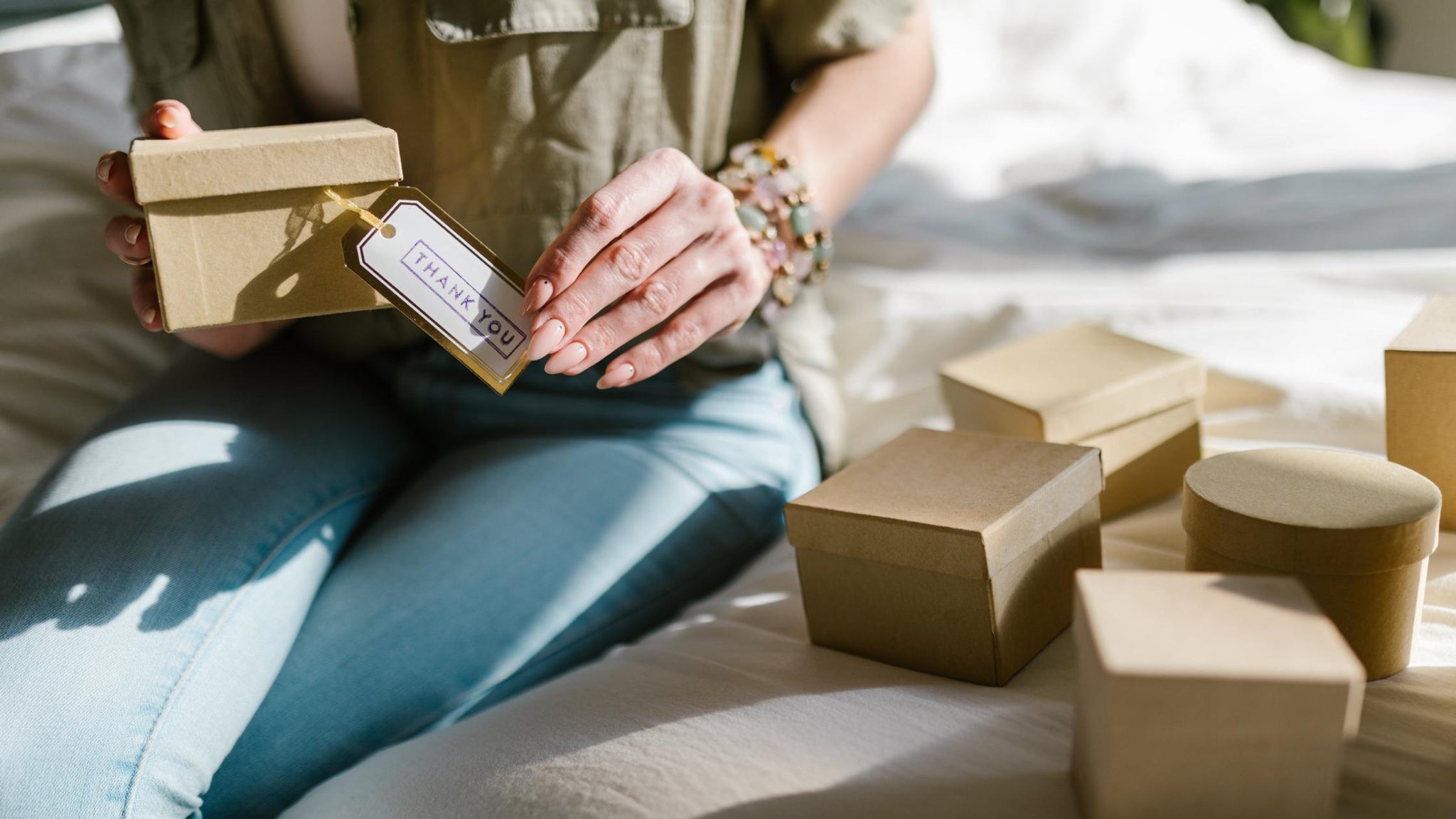 Close-up shot of a woman holding a box with a thank you card