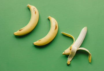 Three Ripe bananas on green surface