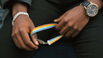 A man holding a rainbow bracelet